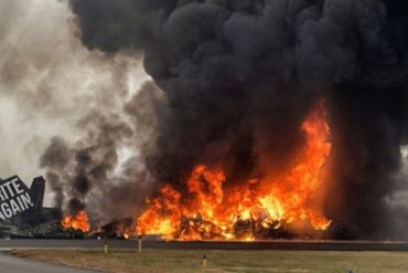 Massive plane crash wreckage engulfed in flames with dark smoke billowing into sky