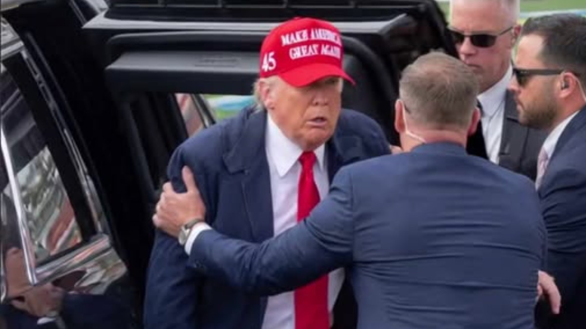 Political figure in red hat surrounded by security detail, subject of Trump misinformation false claim discussions