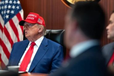 Official discusses Iran deal negotiations at formal meeting with American flag backdrop