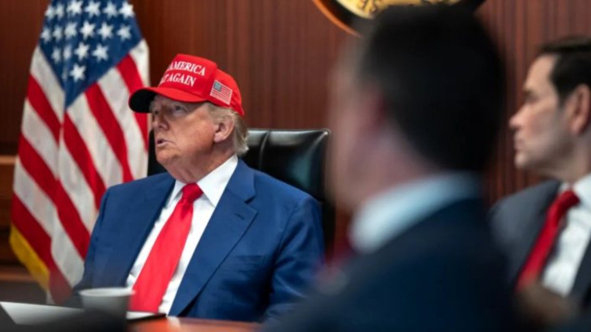 Official discusses Iran deal negotiations at formal meeting with American flag backdrop
