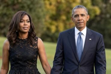 Marian Robinson stands with a man in formal attire on a garden lawn background