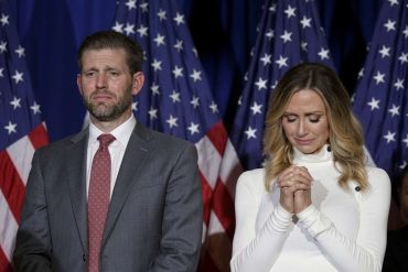 Donald Trump Jr. and companion at Republican leadership event with American flags backdrop