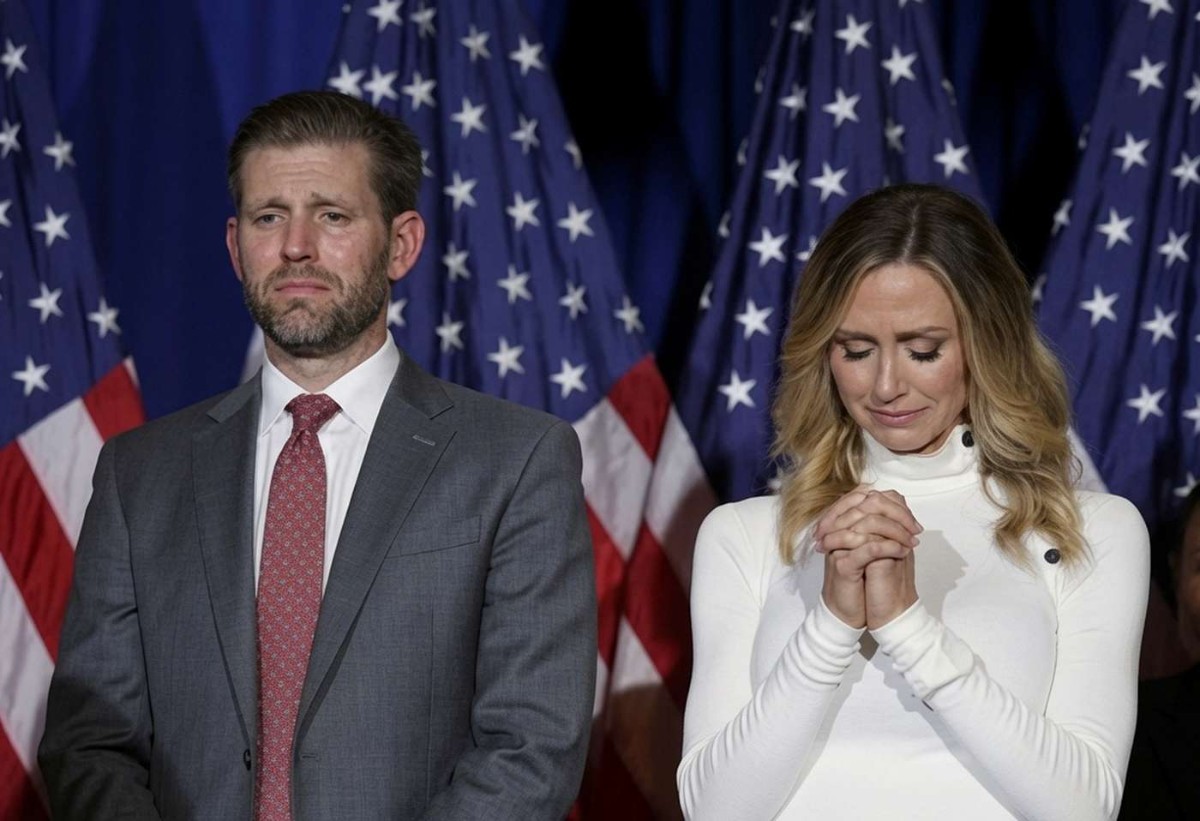 Donald Trump Jr. and companion at Republican leadership event with American flags backdrop